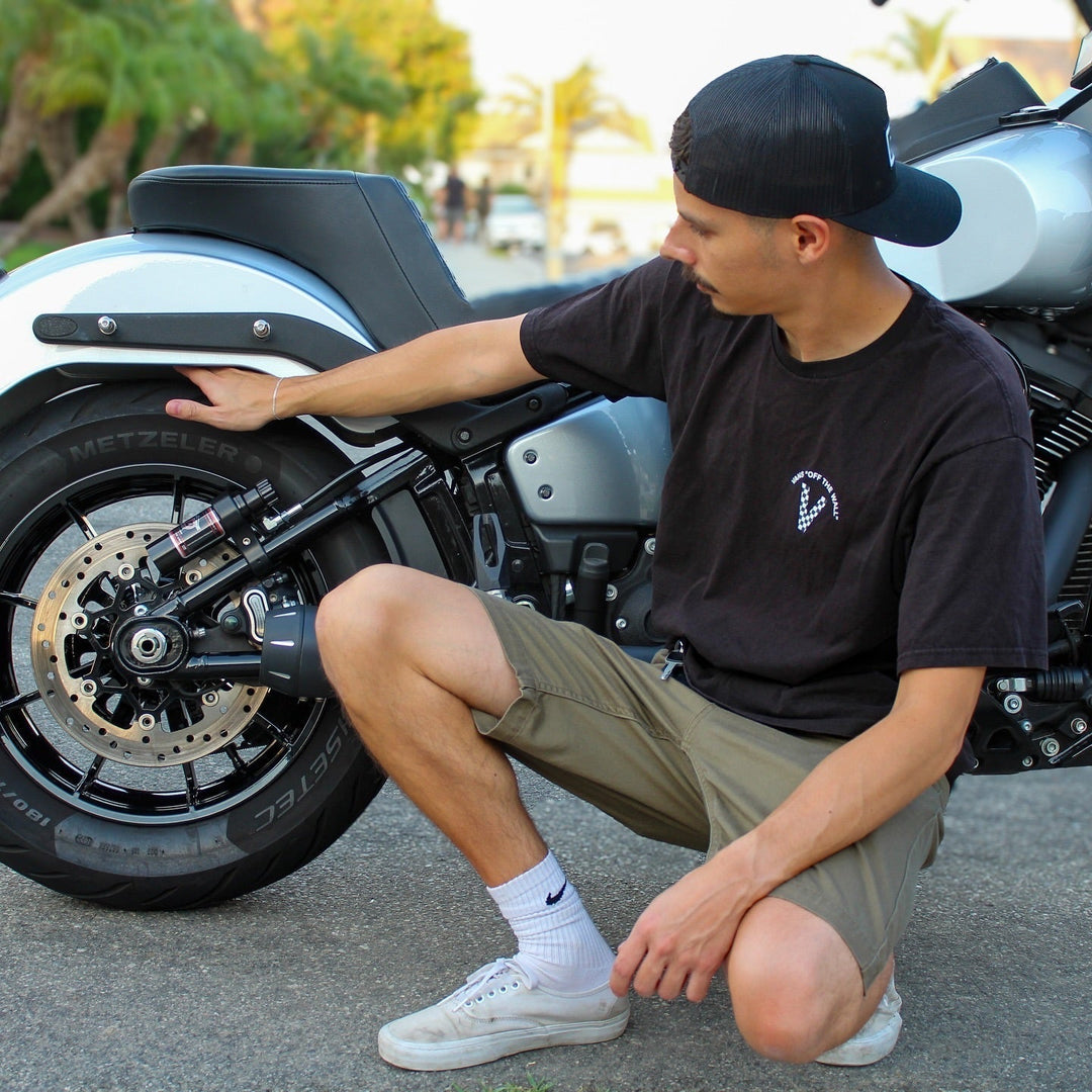 Man crouched next to his Harley Davidson with an RWD RS-2 rear shock absorber installed