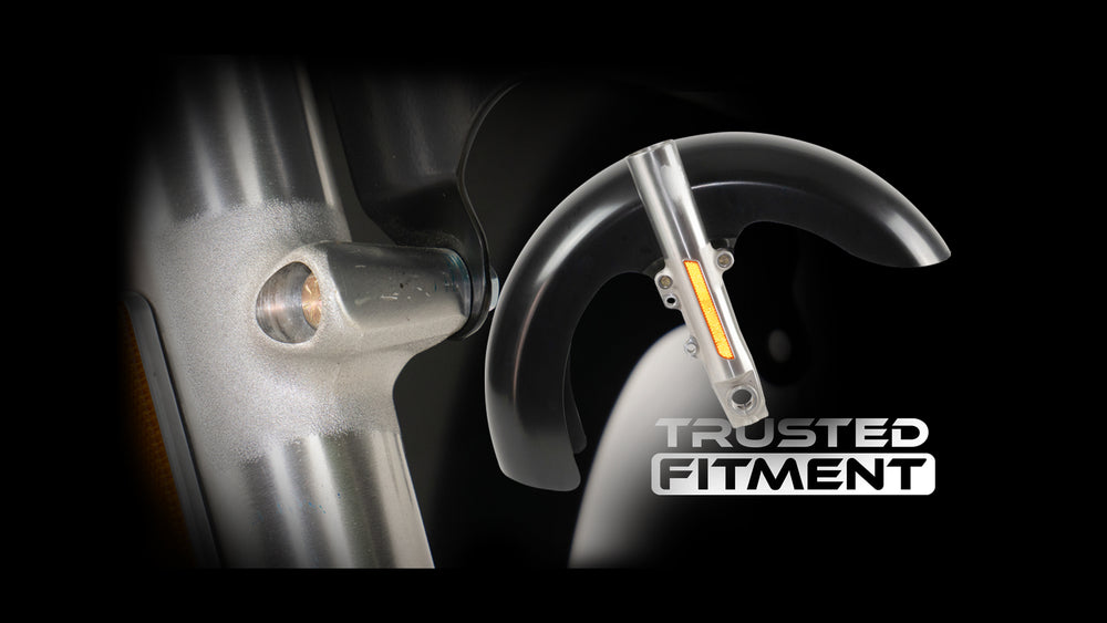 A close-up of RWD V-Twin motorcycle parts, featuring a silver fork assembly with an amber reflector and a black front fender, against a dark background. The text "TRUSTED FITMENT" is visible in the lower right corner.